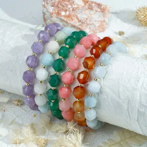 Gedetailleerd uitzicht op kleurrijke gefacetteerde edelsteenarmbanden, stapelbare sieraden.