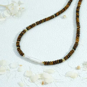 Vue détaillée du collier en perles d'œil de tigre et perle baroque, bijou artisanal vintage.