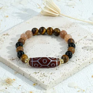 Tibetan style gemstone bracelet detail, featuring multi-color beads and cylindrical dzi center.