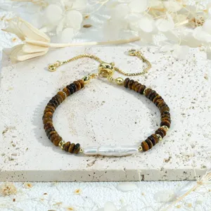 Vue détaillée du bracelet rétro en perles d'œil de tigre et perle baroque avec fermoir doré fin.