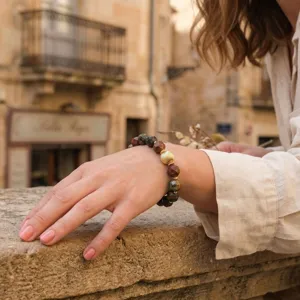 Close-up detail of vintage faceted gemstone bracelet with gold-toned textured bead on wrist.