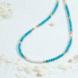 Turquoise and pearl beaded necklace detail view, handmade dainty layered jewelry piece.
