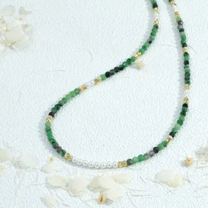Handmade beaded thin necklace featuring green stones, pearls and gold spacers for stacking.