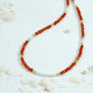 Exquisite beaded necklace with vibrant faceted red beads, pearls, and gold spacers. Chic jewelry.