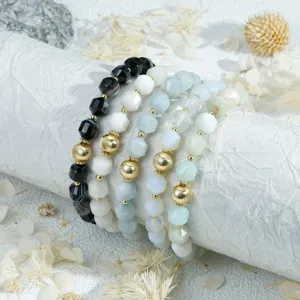 Detailed close-up shot of elegant faceted gemstone beaded stackable bracelets with gold beads.