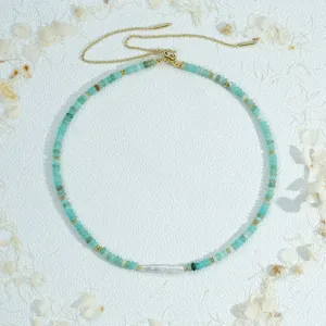 Vue détaillée du collier réglable en perles turquoise et perle baroque avec des finitions dorées.