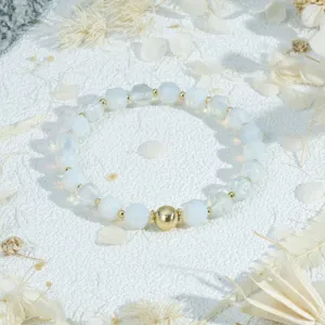 Detailed close-up of faceted white beaded bracelet with gold spacer beads, vintage style jewelry.