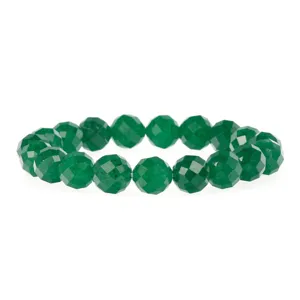 Gedetailleerde close-up van armband met groene gefacetteerde edelsteenkralen en glans.