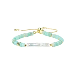 Gros plan détaillé d'un bracelet de perles vertes avec perle baroque centrale et fermoir doré.