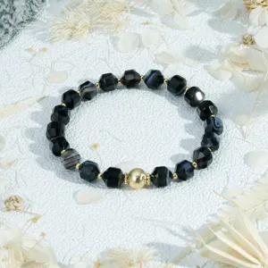 Faceted black bead bracelet with central gold ball, vintage style detail shot for women jewelry