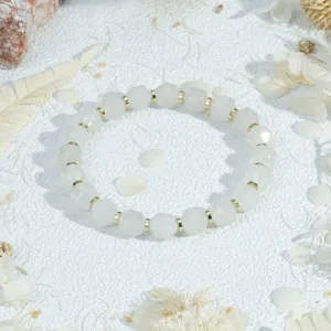 Elegant white faceted bead bracelet with gold spacers, chic minimalist jewelry accessory.