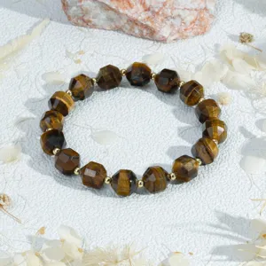 Gedetailleerd overzicht van gefaseerde tijgeroog edelsteen kralenarmband met gouden kralen.