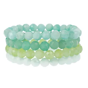 Detailed close-up view of stacked multi-color faceted crystal gemstone bead bracelets.