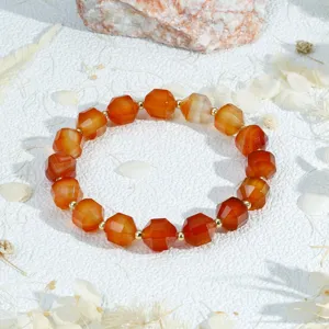 Detailfoto van het gefacetteerde oranje edelstenen armbandje met gouden afstandhouders.