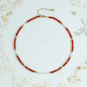 Handmade red beaded choker necklace featuring faux pearls and delicate gold chain details.