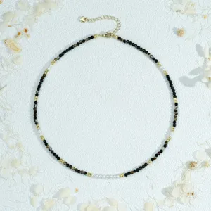 Detailed close-up of dainty beaded choker necklace featuring faceted stones and pearls.