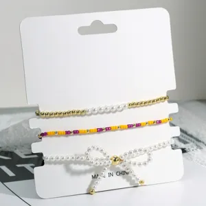 Detailansicht eines zarten, mehrlagigen Perlenarmband-Sets mit niedlicher Schleife und bunten Perlen.