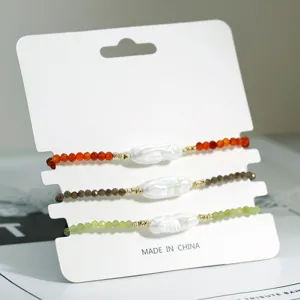 Gedetailleerd overzicht van handgemaakte kralenarmbanden met parels en kleurrijke stenen.