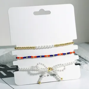 Stapelbares Perlenarmband Set mit zarter Perlen Schleife und bunten Perlen Designs.