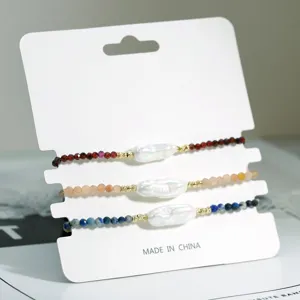 Gedetailleerd overzicht van de set onregelmatige barokparel en edelsteenarmbanden.