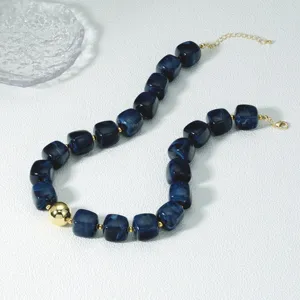 Detailansicht der stilvollen blauen Acryl Wuerfel Perlenkette mit eleganten Gold Akzenten.