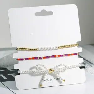 Detailansicht des mehrlagigen Perlenarmband Sets mit feinen Perlen Schleifen und bunten Perlen.