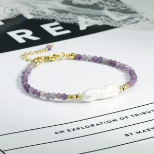 Close-up detail van barok parel en paarse amethist kralen armband met gouden ketting.