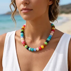 Primo piano di una collana di perline in acrilico colorate con distanziatori d'oro.