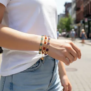Detailopname van kleurrijke halfedelstenen kralenarmbanden gedragen om een pols buiten.