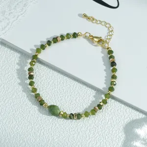 Primer plano detallado de pulsera de cuentas verdes con detalles en metal dorado y cierre.