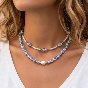Close-up detail of double layered blue white porcelain ceramic beads and baroque pearl necklace.