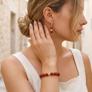Vista detallada del conjunto de pulsera y pendientes de cuentas rojas naturales con oro.