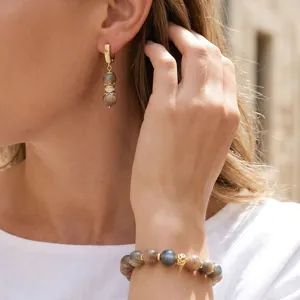 Detalle de juego de joyas de piedra natural con pulsera de cuentas y pendientes de oro