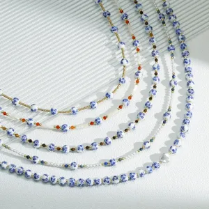 Close-up detail shot of layered blue and white porcelain bead necklaces with pearls.