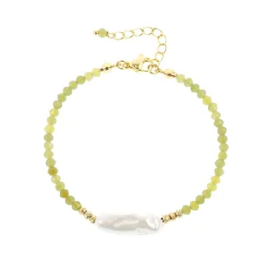 Close-up van de armband met groene kralen en barokparel, met gouden details en sluiting getoond.
