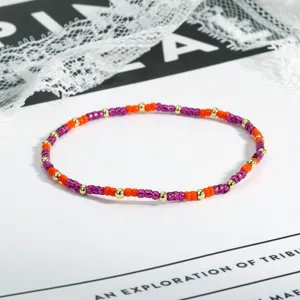 Buntes Perlenarmband, violette und orangefarbene Saatperlen mit goldenen Abstandsperlen.