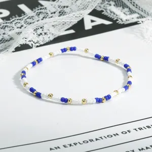 Nahaufnahmedetail der zarten blauen, weißen und goldenen Perlenarmband-Oberflächentextur.