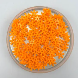 Primo piano perline fiocco plastica arancione, perfette per decorare cover e nail art DIY.
