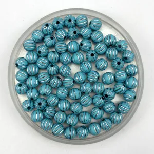 Detailed view of turquoise acrylic pumpkin beads with silver stripes for DIY jewelry making.
