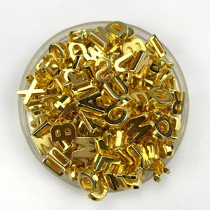 Detail shot of shiny gold alphabet letter and number beads for DIY jewelry making.