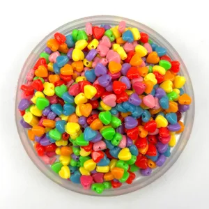 Colorful heart plastic beads closeup, vibrant mixed candy colors for DIY jewelry craft bulk.