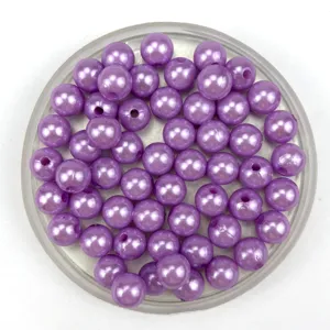 Close-up of purple imitation pearl craft beads in a tray, perfect for DIY jewelry making.