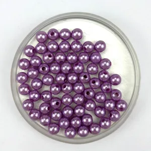 Close-up detail of purple ABS plastic faux pearl beads with pre-drilled holes for DIY jewelry.