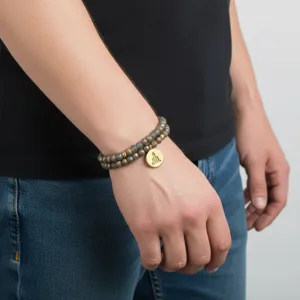 Detalle de la pulsera de cuentas multicapa con un elegante colgante dorado y abalorios.