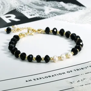 Gedetailleerd overzicht van de Boheemse kralenarmband met zwarte kralen en witte parels.