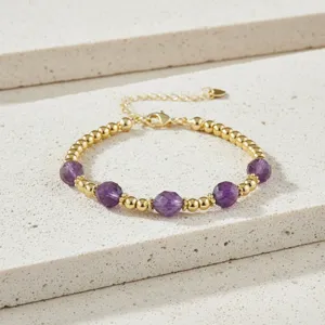 Elegante vintage kralenarmband met paarse halfedelstenen en gouden metalen kralen.