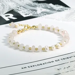 Close-up detail van boho rozenkwarts edelsteen en parel kralen armband sieraden