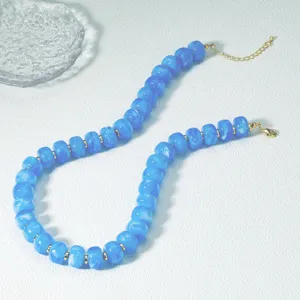 Chic collana di perle in acrilico blu con parti in metallo dorato, ideale per le vacanze estive.