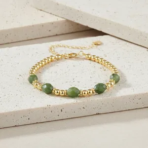 Detail van een prachtige vintage armband van groene edelsteenkralen met gouden ketting.