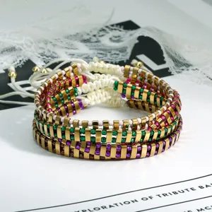 Detailopname van bohemian handgemaakte geweven kralenarmband met metalen buizen en kleuren.